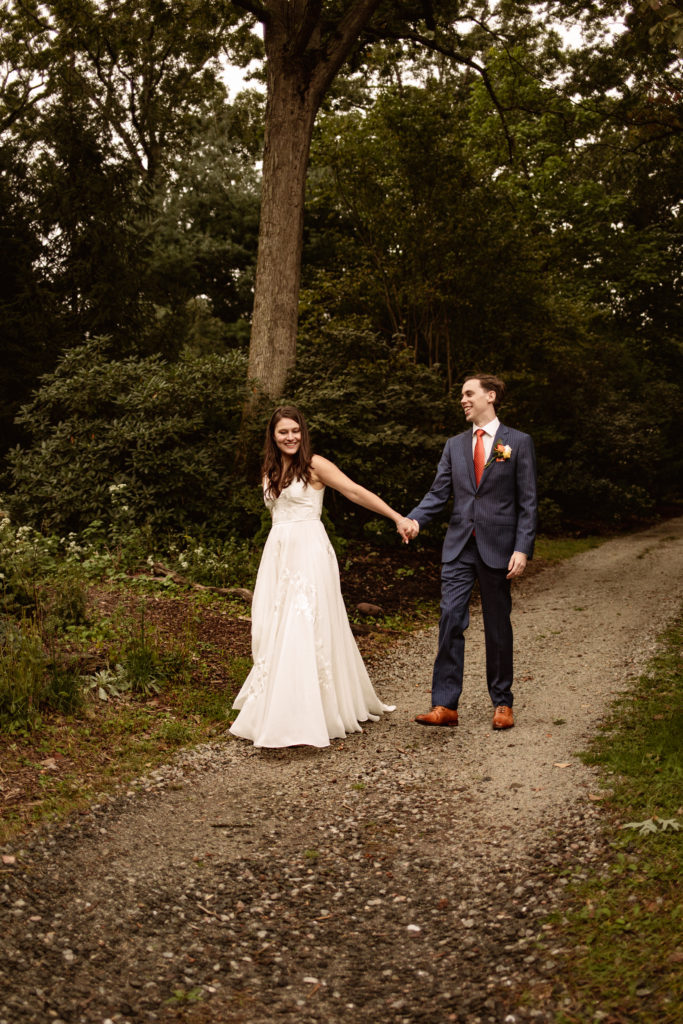 Bride and groom walking in laurelwood arboretum