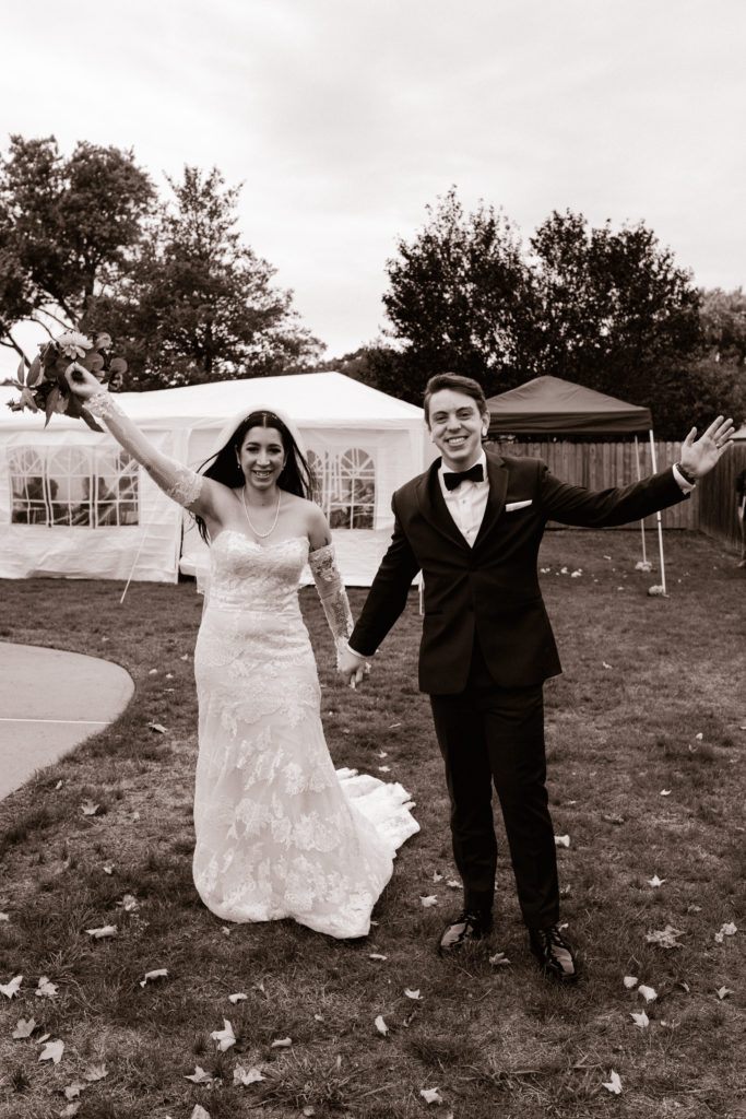 bride and groom with their hands up at their backyard wedding