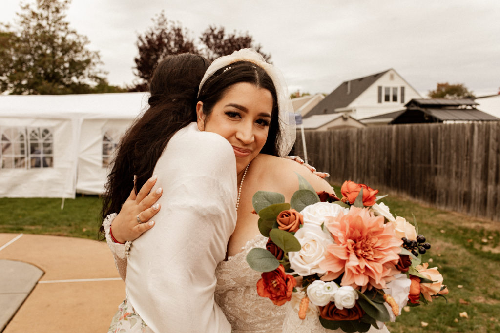 bride hugging her sister at her backyard wedding
