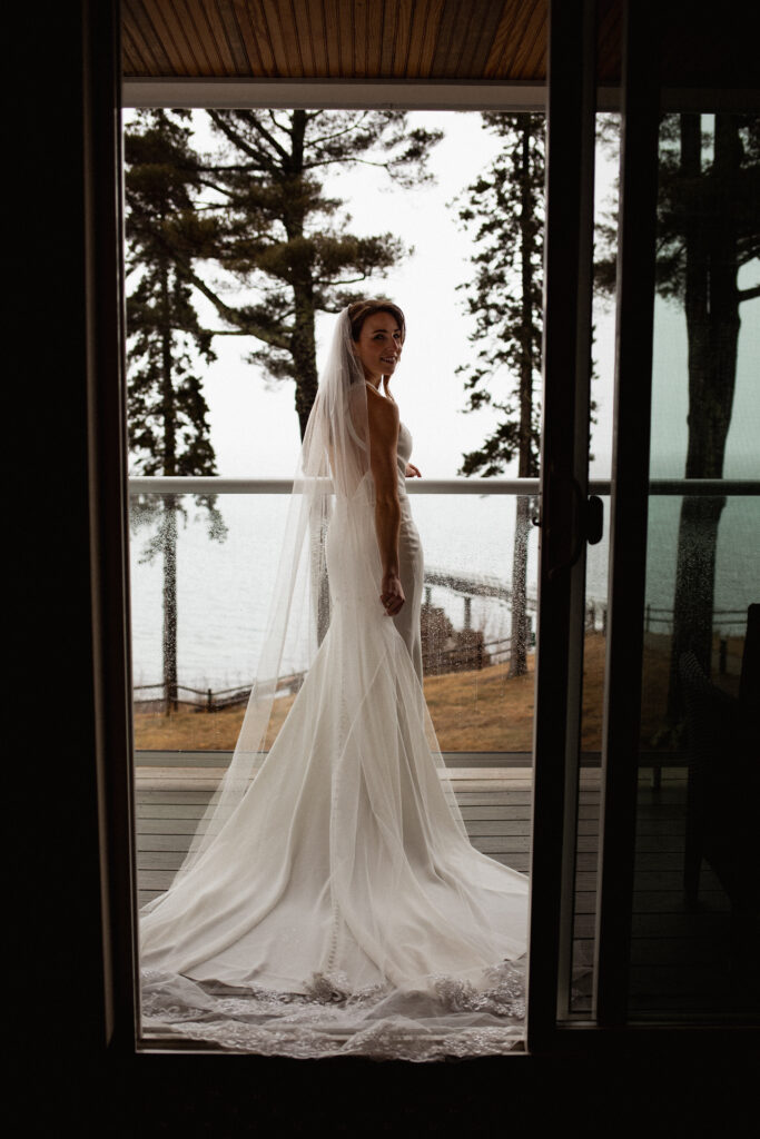 Bride on balcony in Acadia National Park for adventure elopement on a stormy day