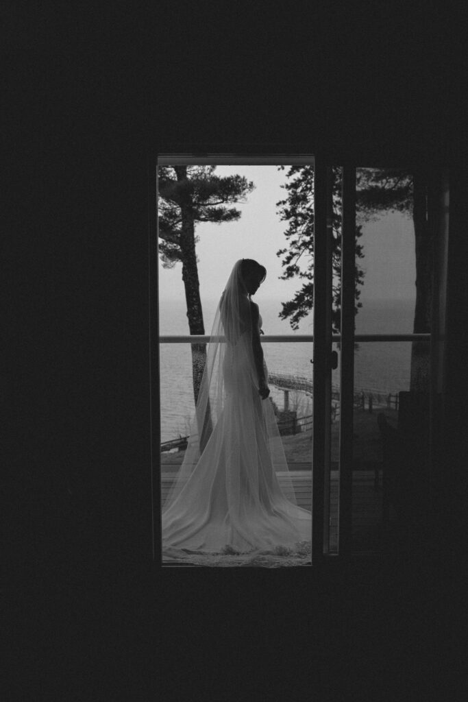 Bride on balcony in Acadia National Park for adventure elopement on a gloomy day