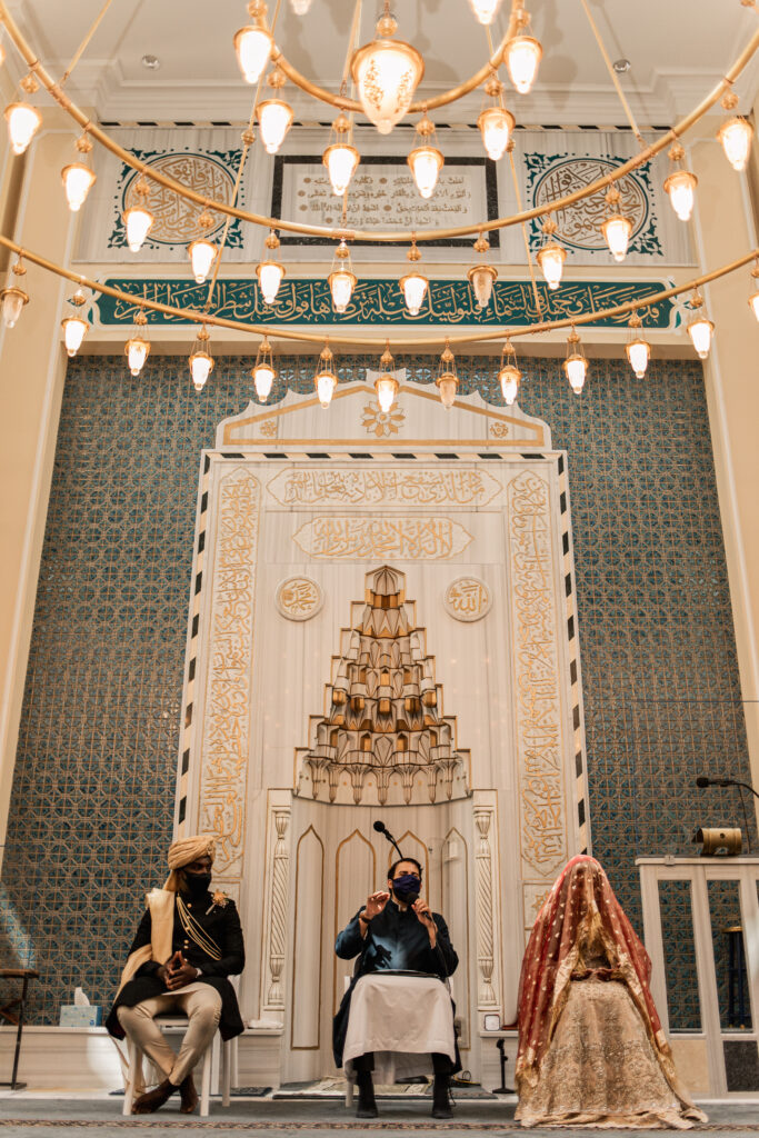 Bride and groom seated on stage during the Nikkah ceremony at the mosque.