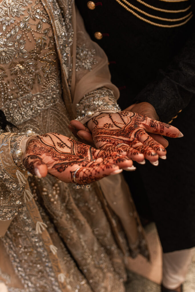 Close-up of the bride's intricate henna designs on her hands.
