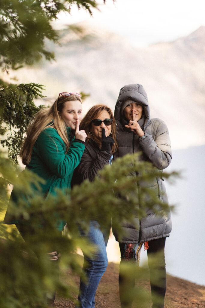 Hidden Surprise: Cassie’s friends peeking out from behind trees, ready to surprise her after the proposal at Crater Lake.

