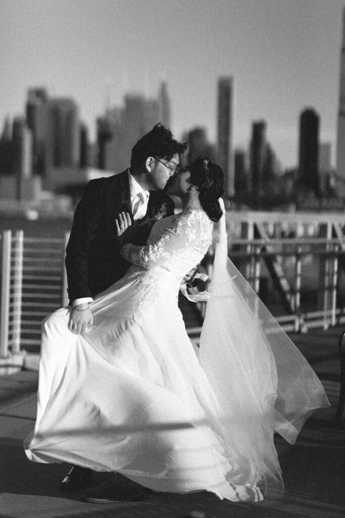 Bride and groom sharing a dance with the city skyline behind them. New Jersey wedding photographer near me for intimate weddings.
