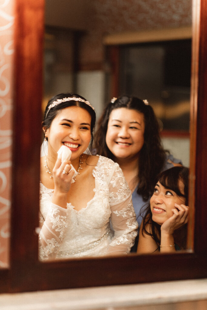 Bride applying lipstick with bridesmaids. Intimate wedding photographer in NJ for small, intimate weddings.

