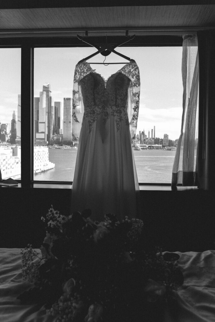 Wedding dress hanging against a city skyline. NJ wedding photojournalist capturing the essence of intimate wedding photography.
