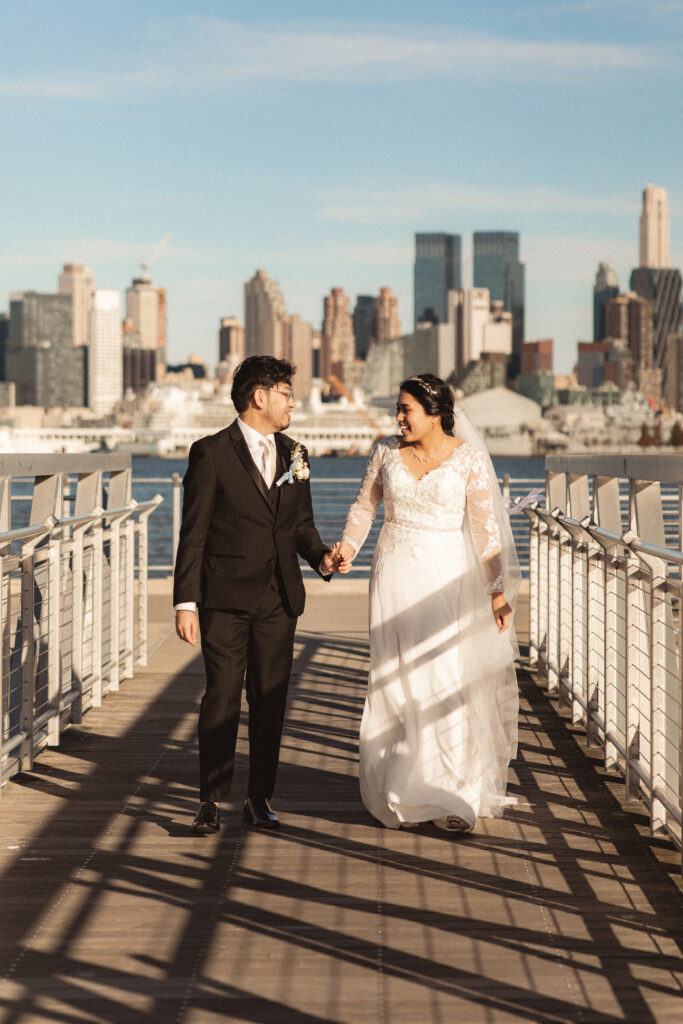 Bride and groom walking and talking together on the pier. New Jersey documentary wedding photographer for elopement photography.
