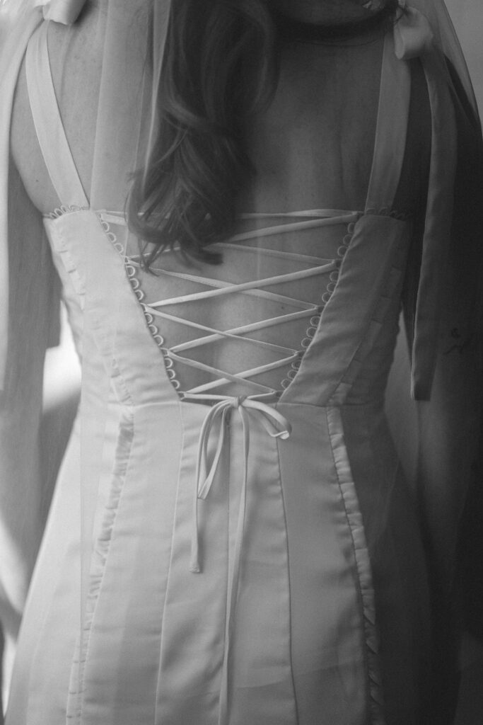 Close-up of the bride's dress lace-up back, emphasizing the details.
