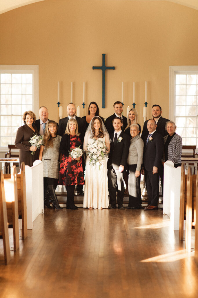 Group photo with family and friends at the altar, celebrating the couple's special day.
