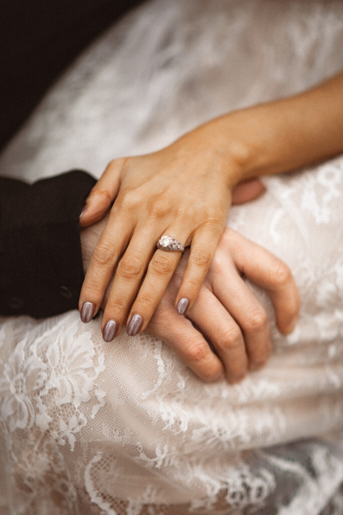 Close-up of Fran and Frank's hands, with Fran's engagement ring visible.

