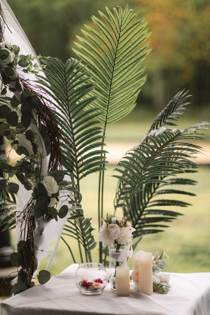 Elegant floral and candle arrangement on a table, enhancing the beauty of the wedding decor.
