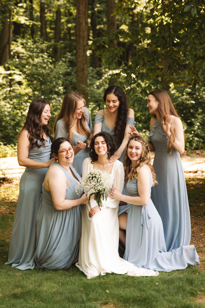 Bride and bridesmaids standing in a line, all holding bouquets.
