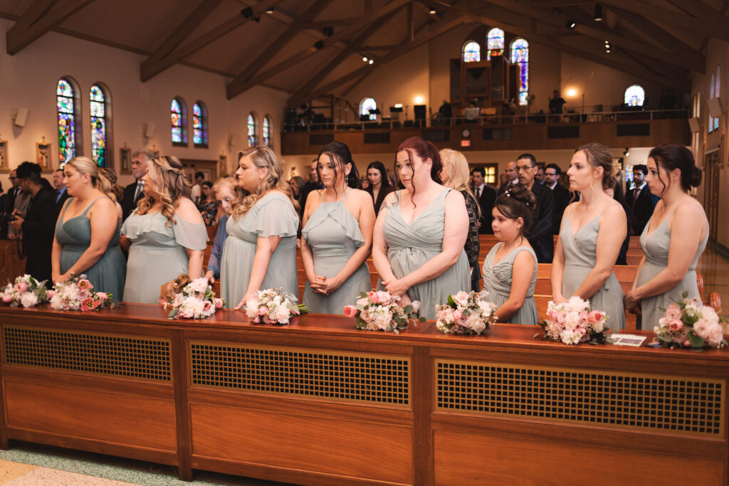 Briana and her bridesmaids seated in the church pews during the ceremony.