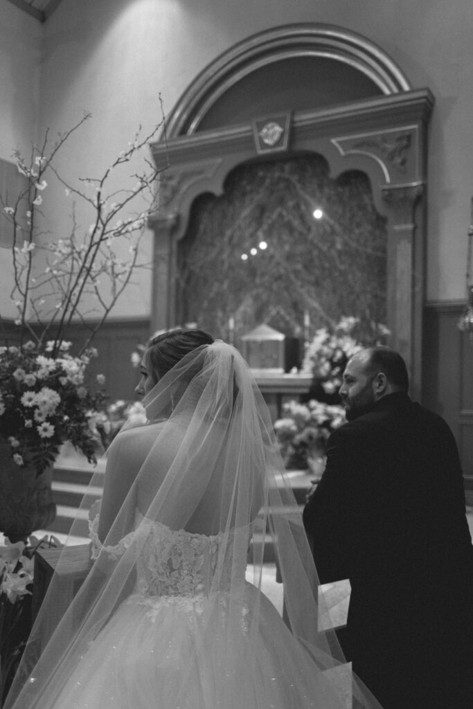 Black and white photo of Briana and Pat walking up the aisle after their ceremony.

