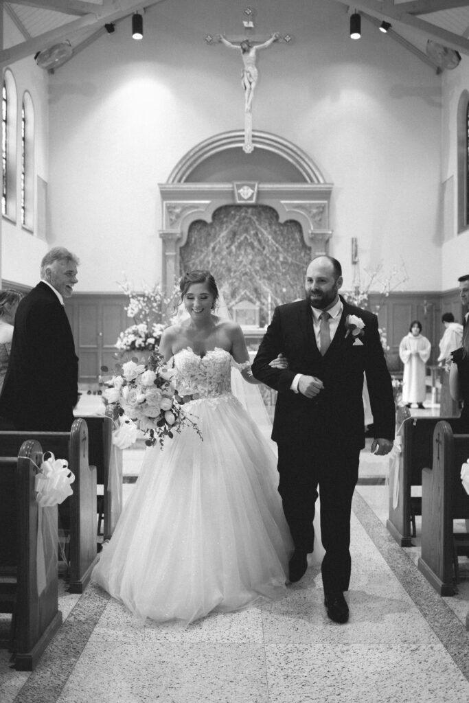  Briana and Pat walking down the aisle inside the church after their ceremony.