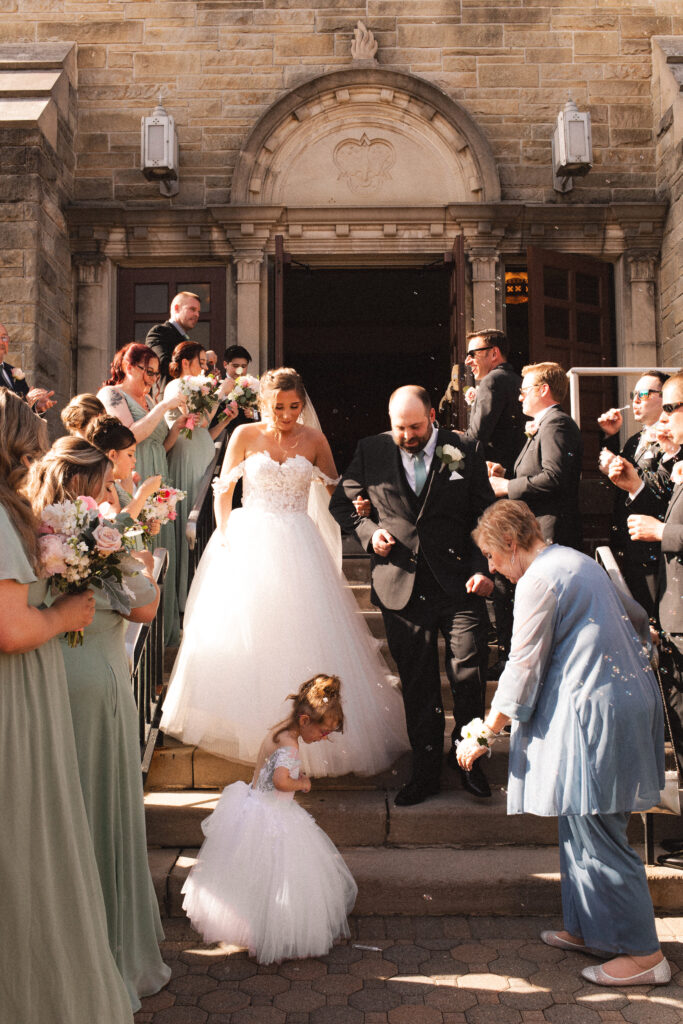 Guests and bridal party celebrating outside the church as Briana and Pat exit.

