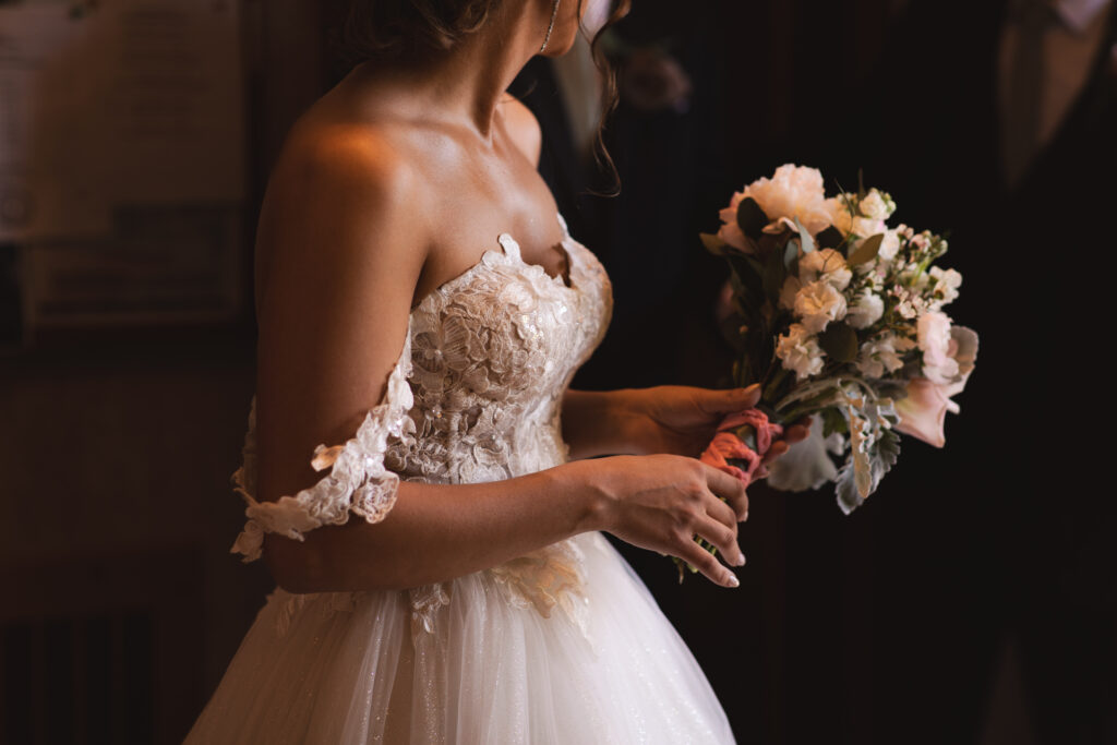 Briana holding her bouquet, standing inside the church.