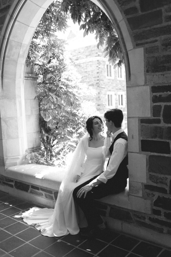 Bride and groom sitting together in an archway, sharing a quiet moment.